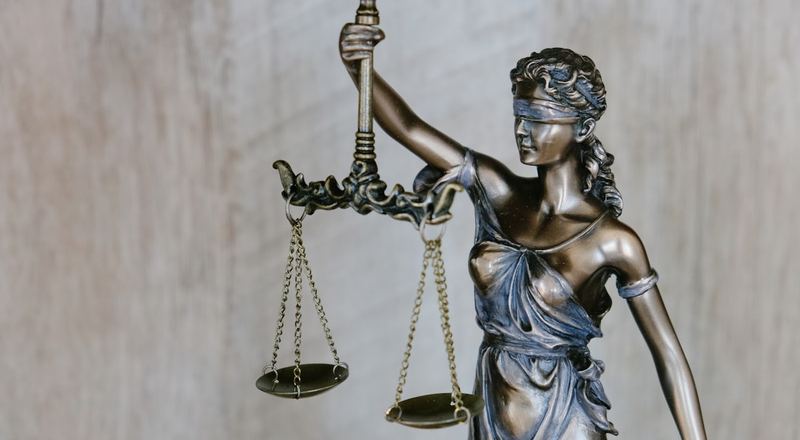 Mesa de escritório de advocacia com balança da justiça e documentos