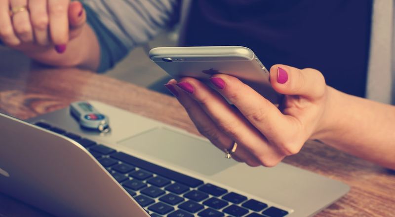 Operadora usando celular e notebook em operação ativa