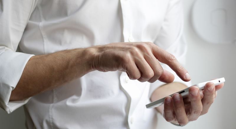 Profissional respondendo mensagens no celular durante o expediente